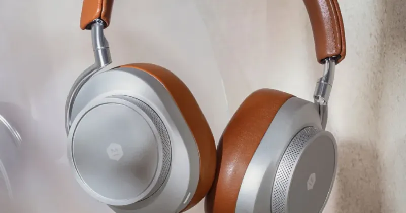 Tan leather and silver over-ear headphones on a pale background