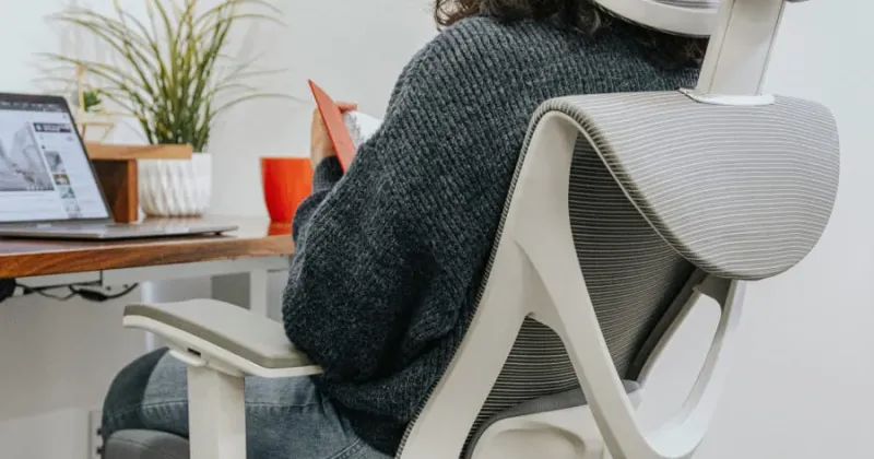 Person working at a desk in an ergonomic mesh office chair
